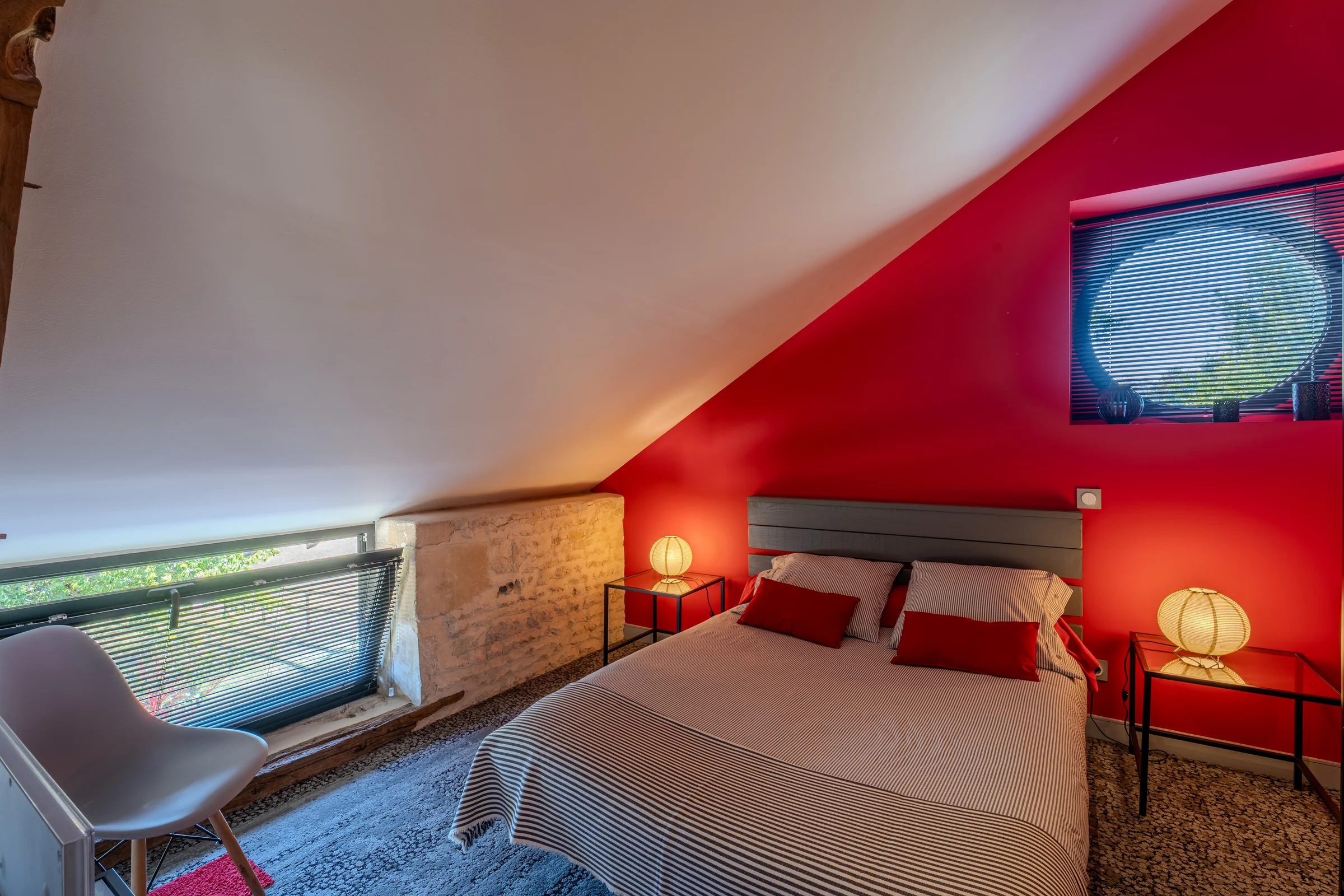 Chambre sous combles aux murs rouges.
