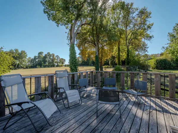 Terrasse en bois avec vue sur un paddock.