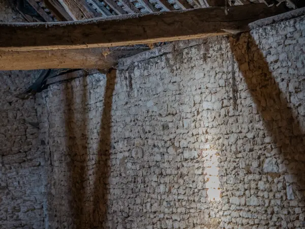 Ancien grenier aménageable : détail de mur en pierre sous la charpente.