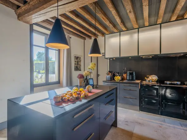 Cuisine, îlot central et cuisinière piano.