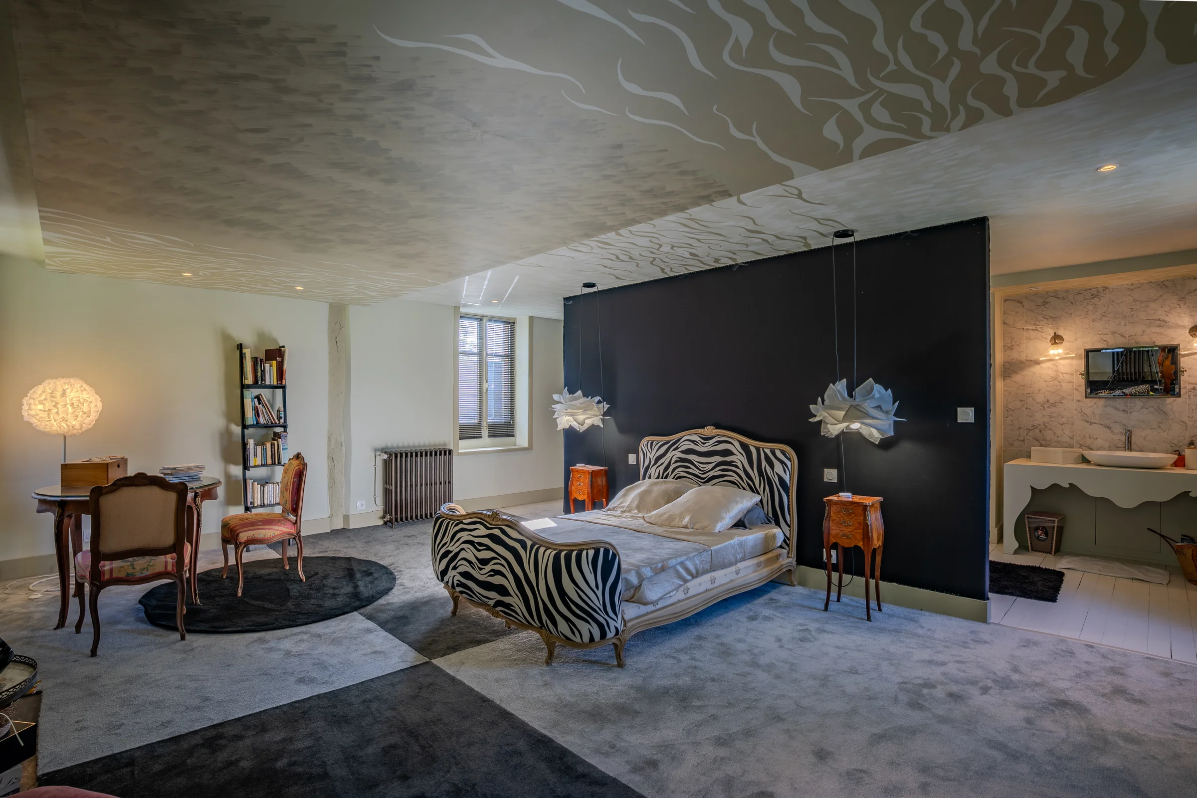 Chambre avec coin bureau et bibliothèque.
