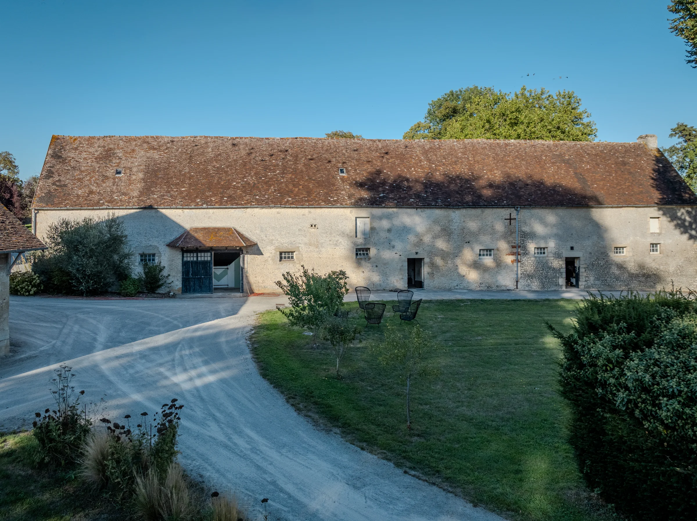 Façade des écuries, abords engazonnés.