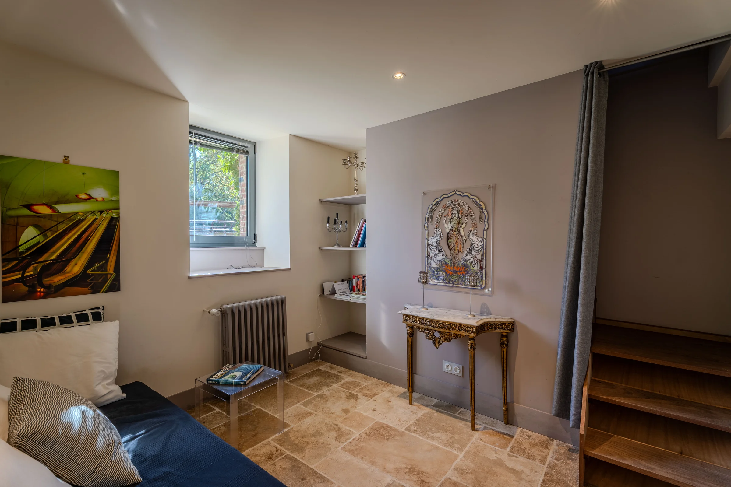 Coin salon avec console décorative et étagères.