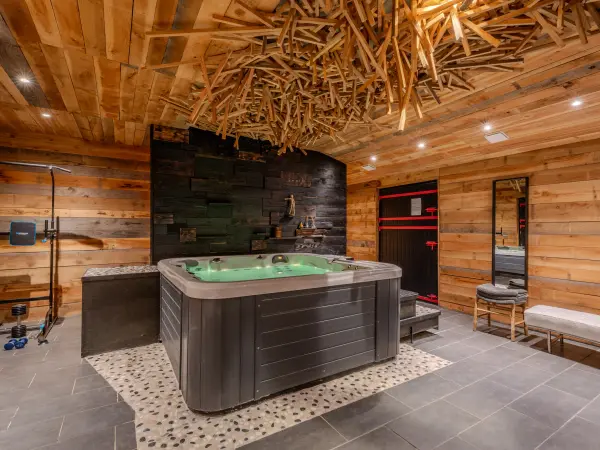 Spa avec jacuzzi sous plafond en bois composé.