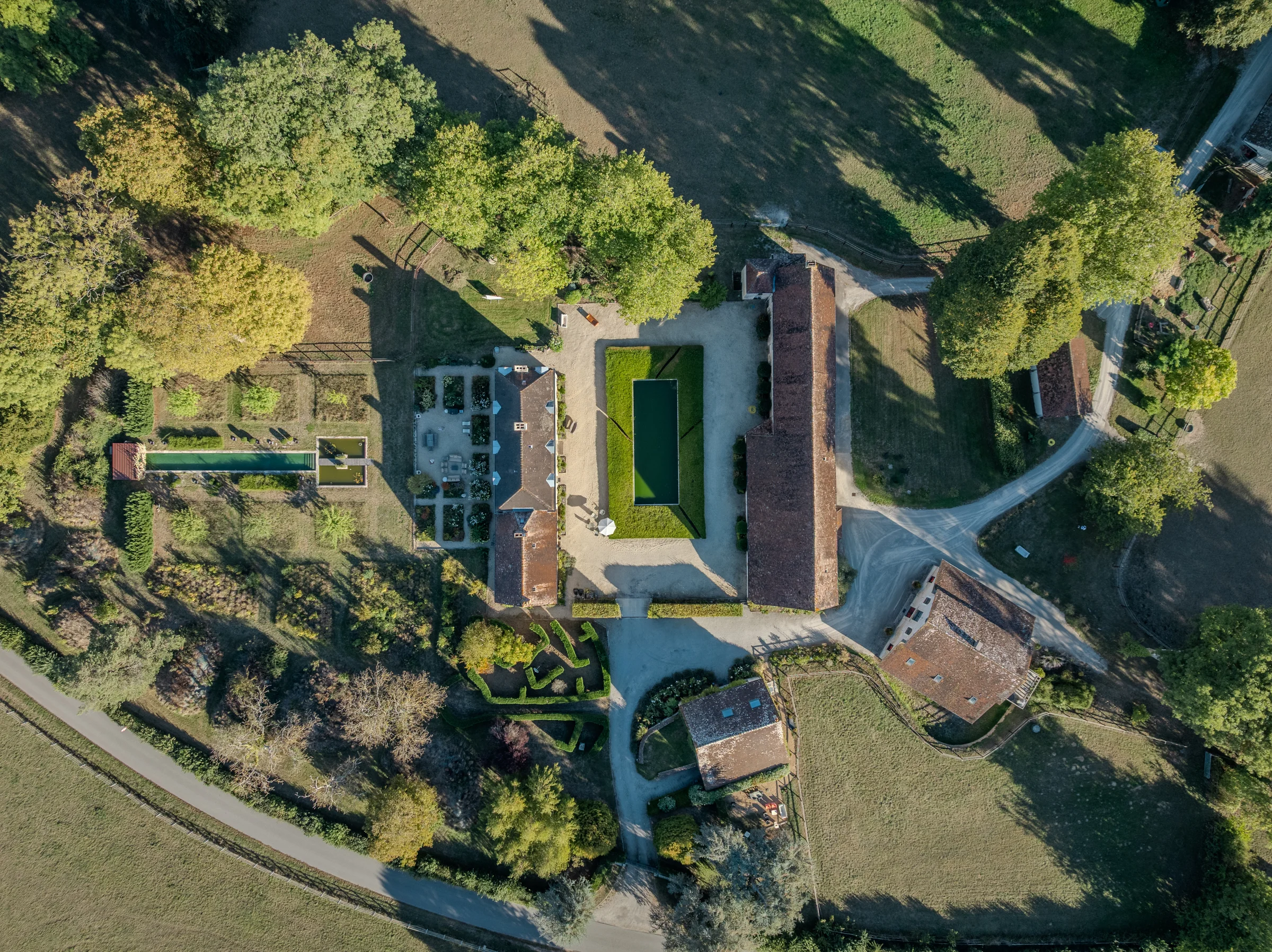 Vue aérienne globale du domaine : jardin, piscine, manoir, écuries, grand gîte et petit gîte.