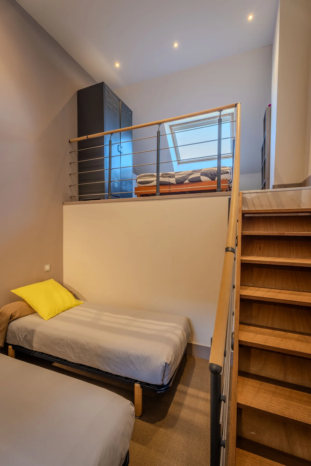 La chambre en duplex avec mezzanine et fenêtre de toit.