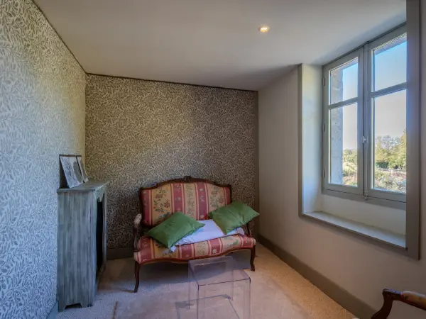 Coin lecture dans la chambre et fenêtre sur l'extérieur.