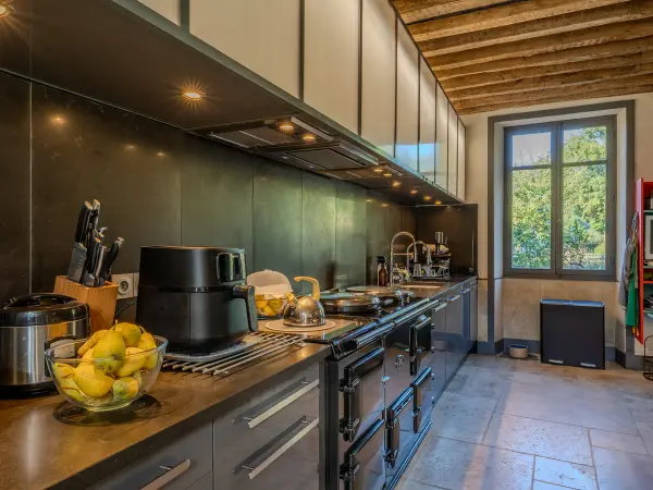Cuisine, plan de travail et cuisinière piano.