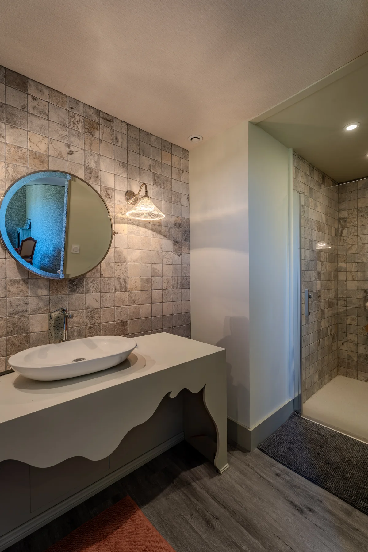 Salle de bains avec vasque posée et douche à l'italienne.