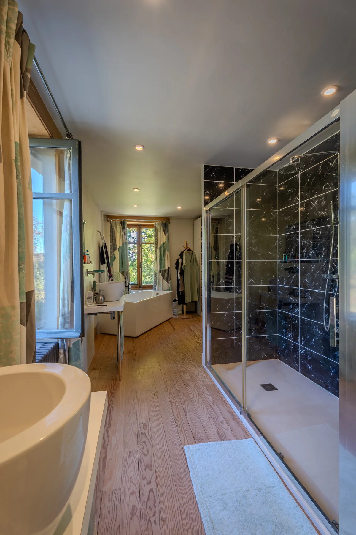 Salle de bains, baignoire îlot et douche vitrée.