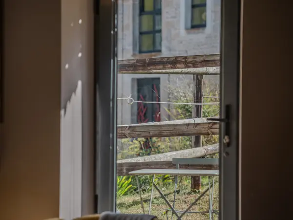 Vue depuis l'intérieur vers la terrasse et le grand gîte.