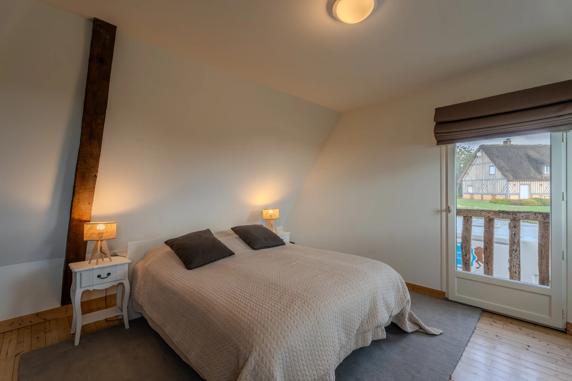 Chambre à l'étage, fenêtre ouvrant sur un balcon.