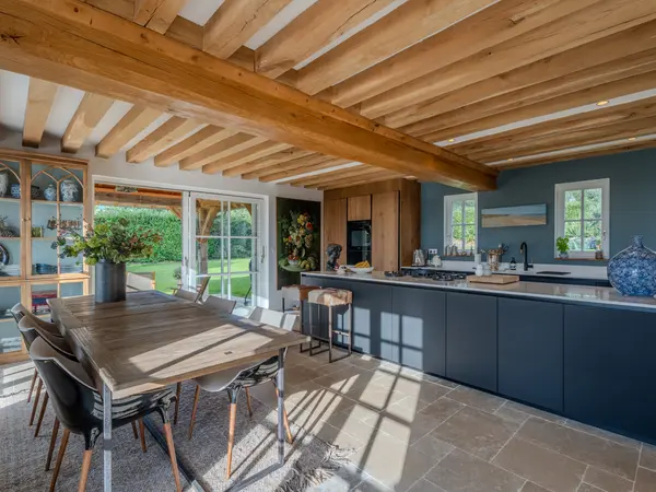 Salle à manger ouverte largement sur le jardin par une baie coulissante.