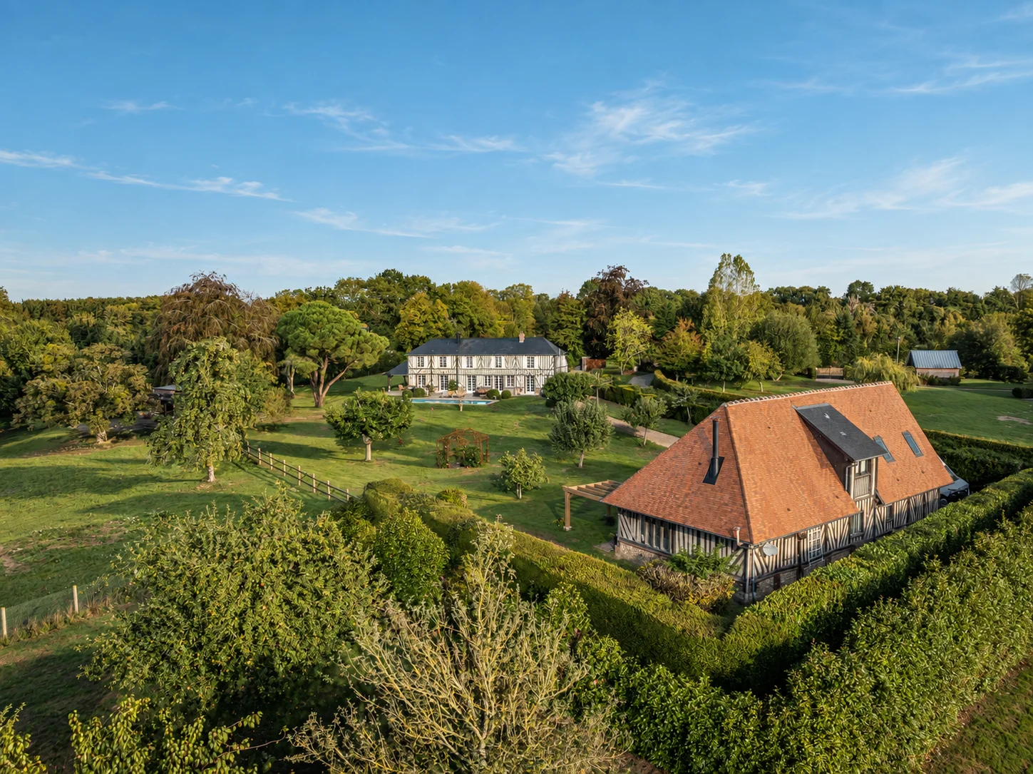 Vue aérienne du domaine avec maison principale et dépendance séparées par des haies.