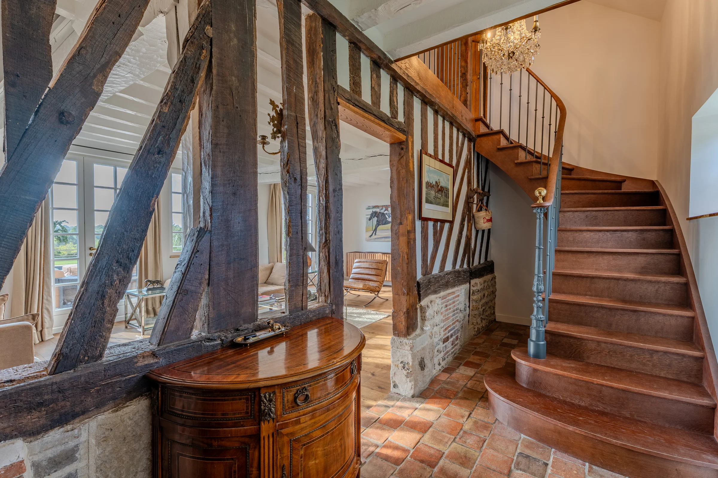Entrée à colombages et escalier en bois.