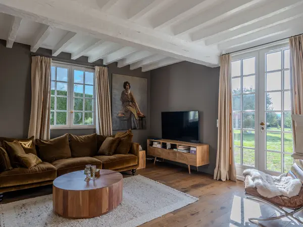 Le salon largement ouvert sur le jardin par des baies à petits carreaux.