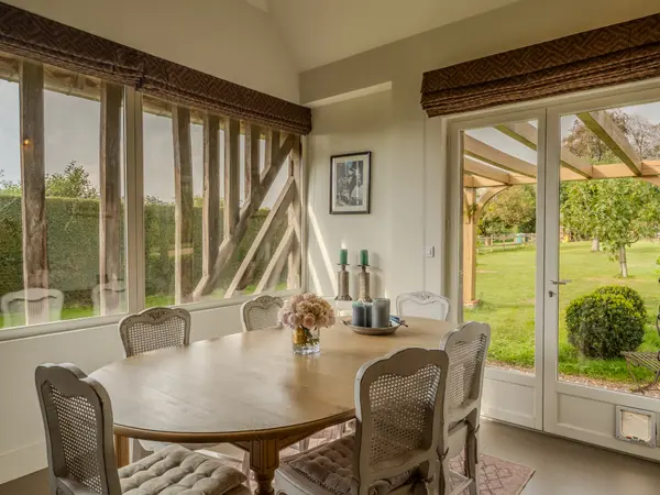 Salle à manger, fenêtre ouvrant sur pergola et jardin.