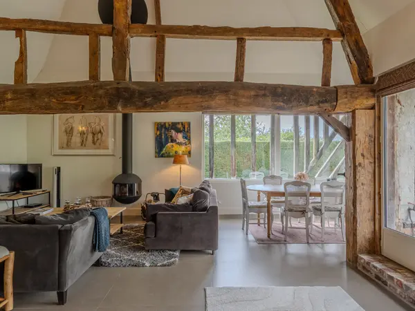 Salon et salle à manger sous charpente, ouverts sur le jardin.