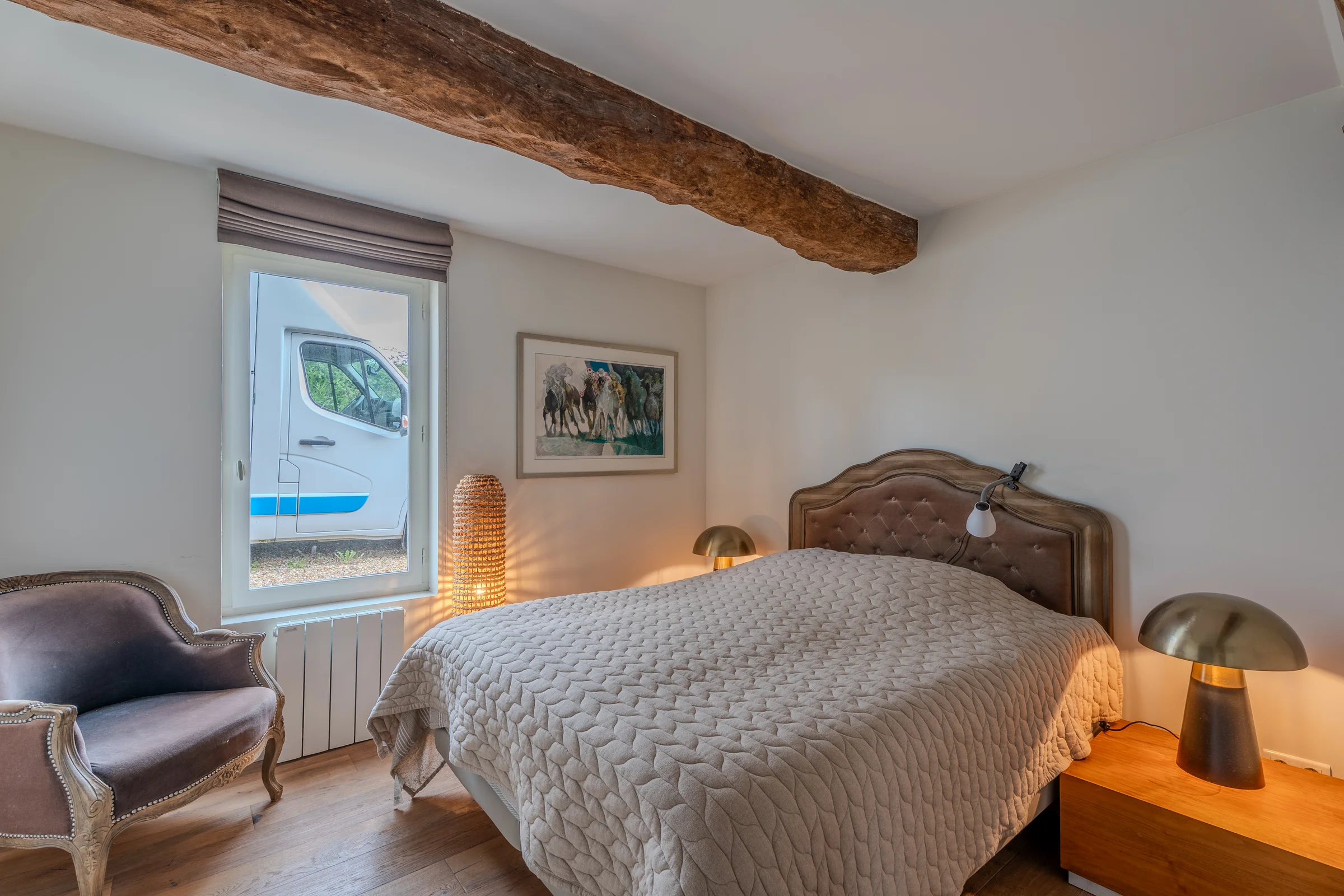 Chambre avec poutre apparente et sol de bois.