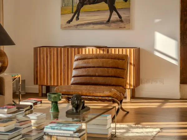 Salon traversé par une lumière rasante, parquet clair.
