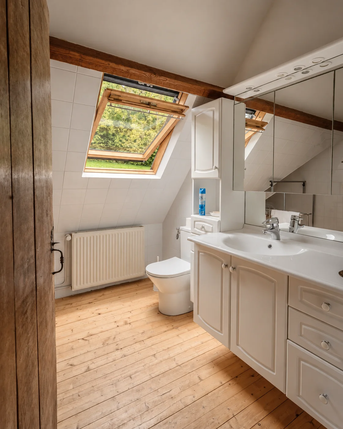 Salle de bains sous velux, meuble vasque blanc.