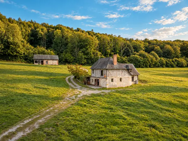 Vue aérienne de la maison et de sa dépendance au milieu des prairies.