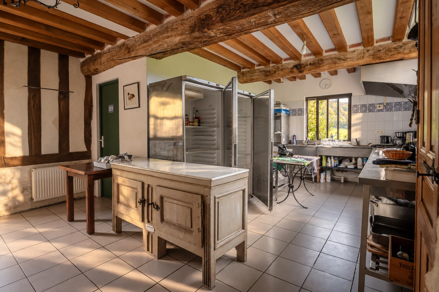 Cuisine avec poutres apparentes et équipement professionnel.