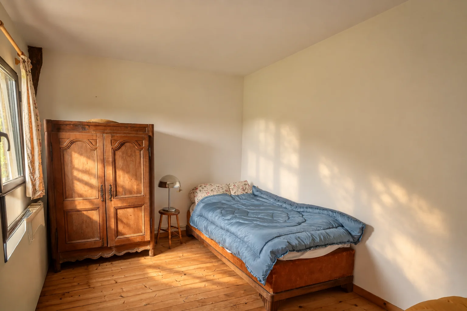 Chambre 2 : lit double et armoire ancienne.