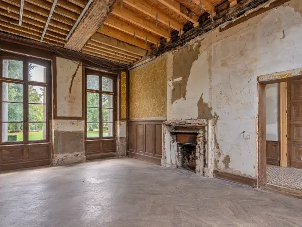 Salle à manger en restauration, cheminée de pierre et parquet en chevrons.
