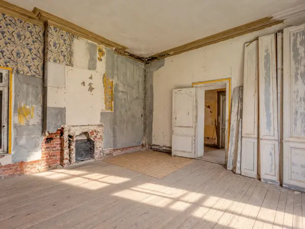 Chambre en travaux : cheminée dégagée et boiseries déposées.