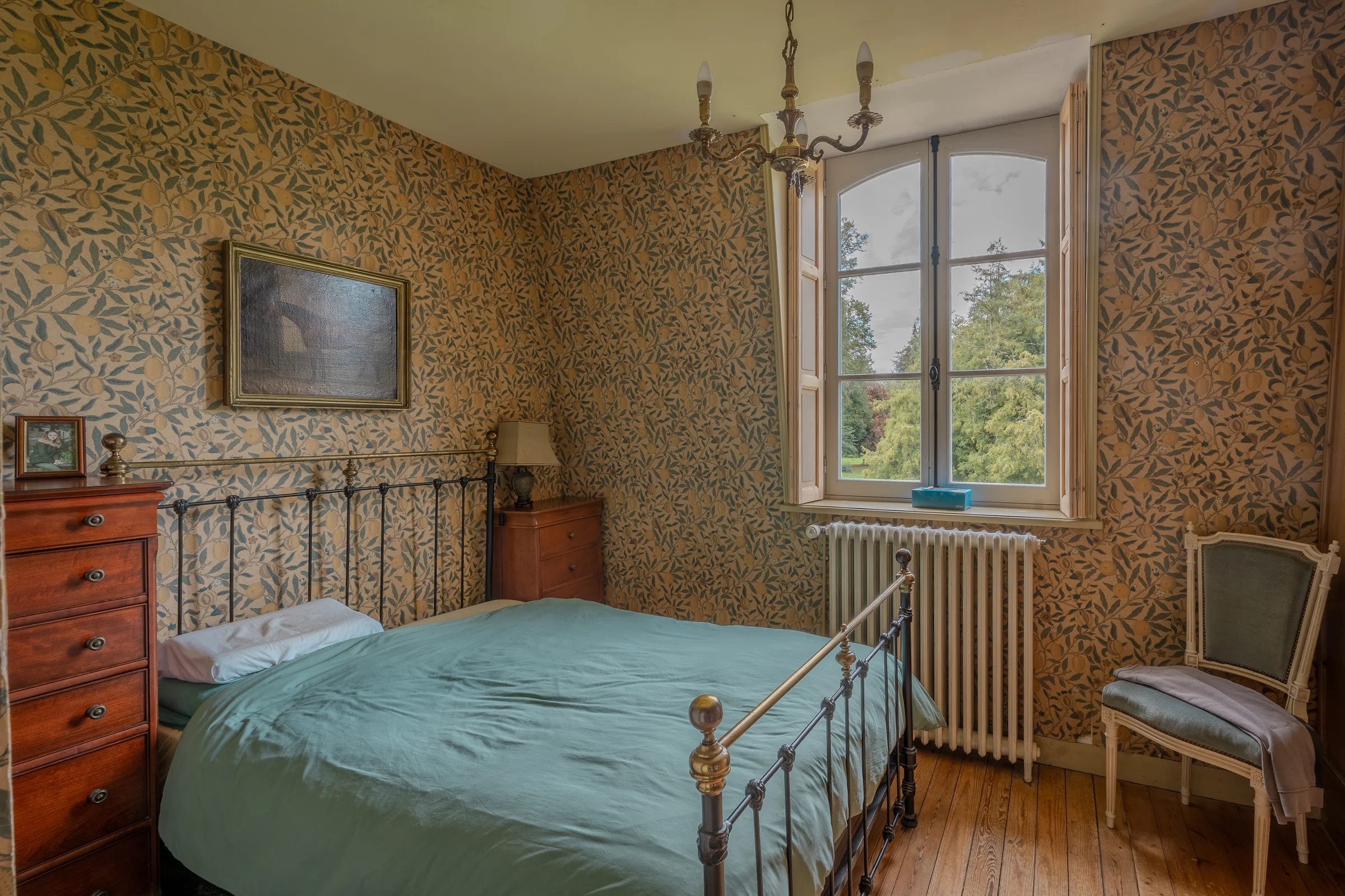Chambre tapissée, fenêtre ouvrant sur le parc.