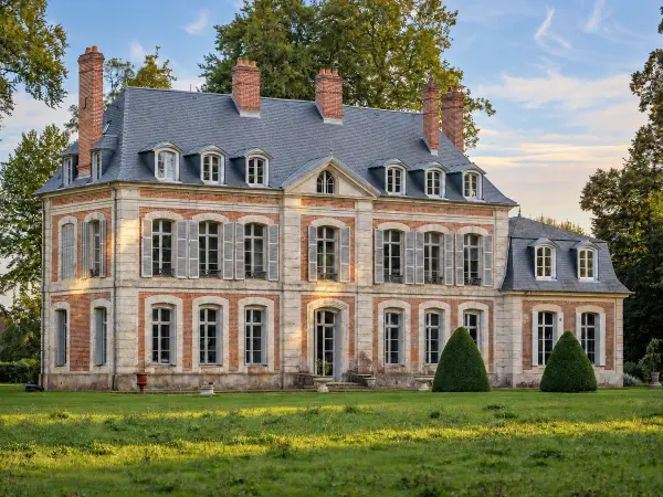 Façade principale, pierre et brique alternées, toiture à lucarnes.