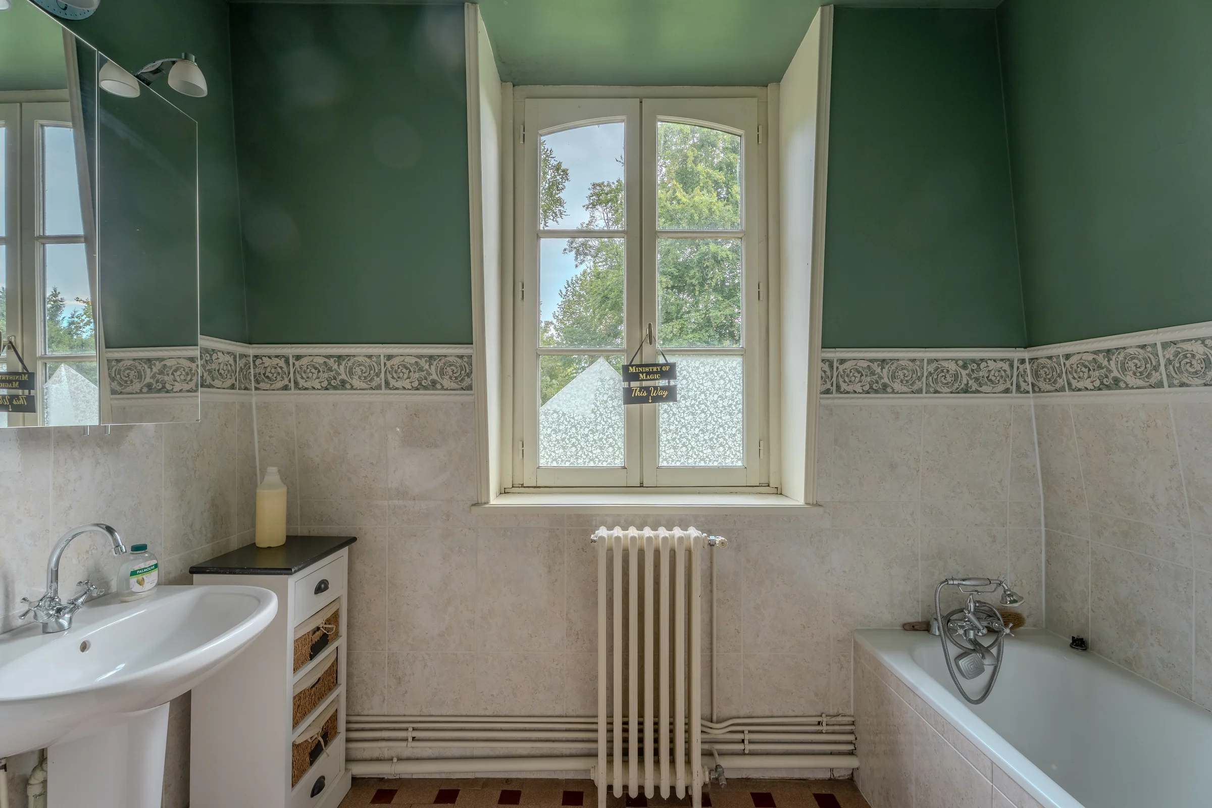 Salle de bains avec baignoire et carrelage à frise décorative.