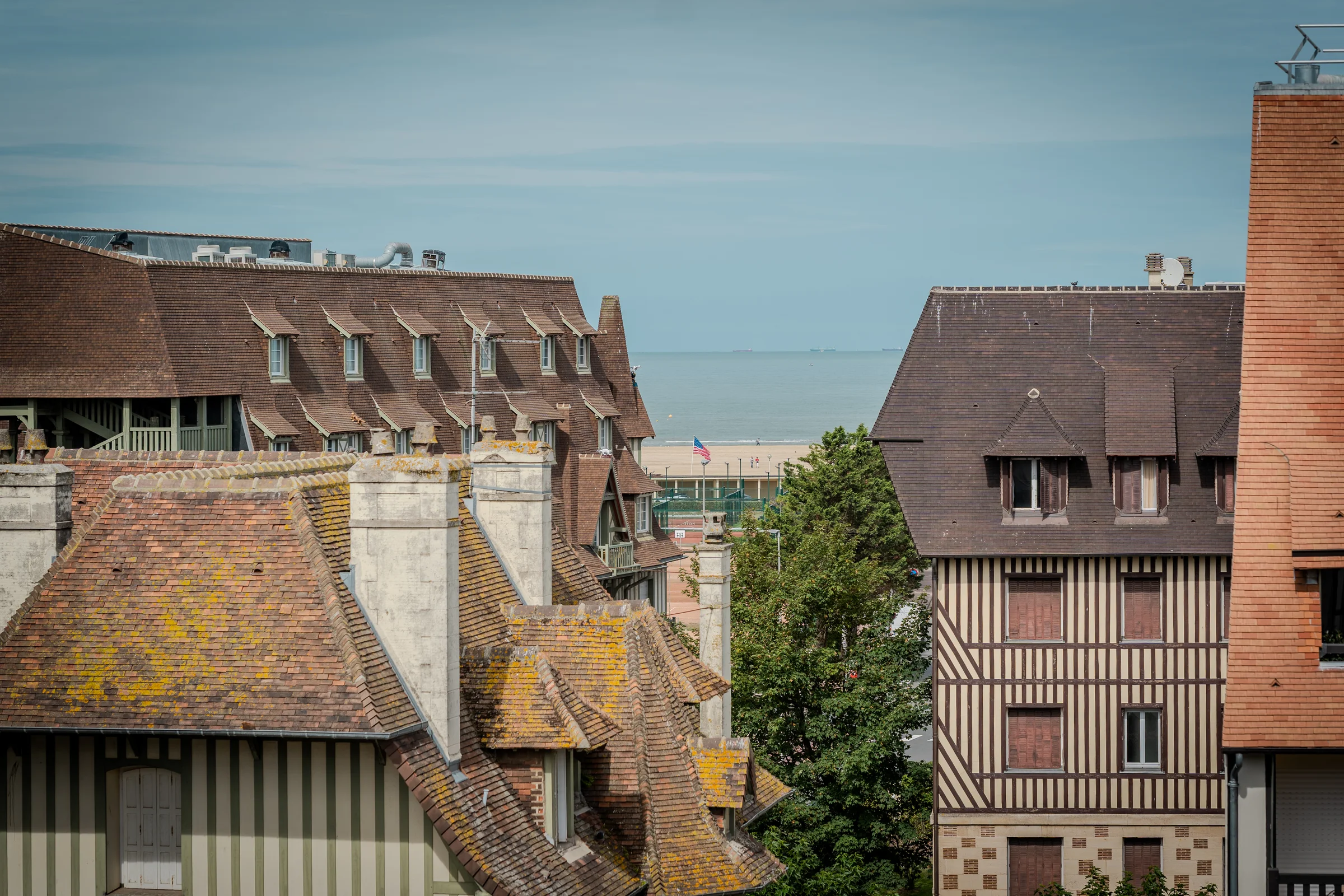 Toits et cheminées de la ville, ouverture sur la mer.