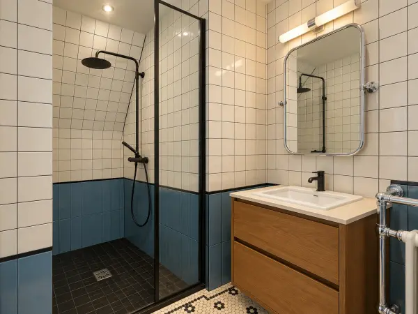 Salle de bains en suite, douche vitrée et vasque sur meuble bois.