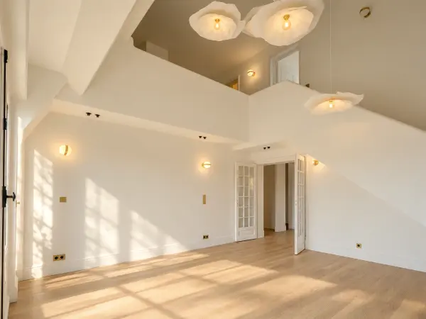Salon du 1er niveau en double hauteur, ouvert sur la mezzanine.