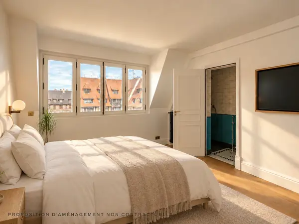 Chambre au parquet clair, et salle de bains attenante.