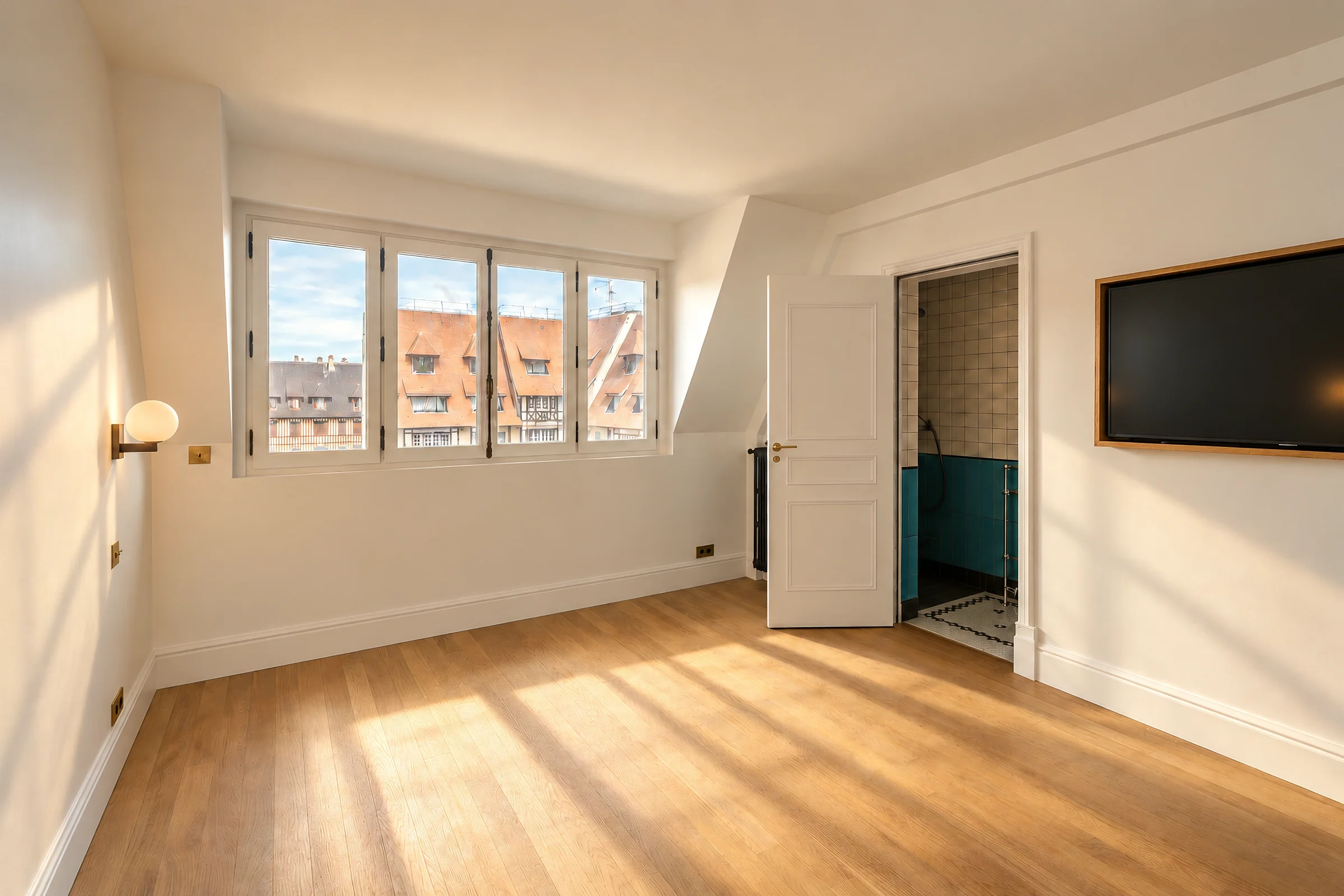 Chambre au parquet clair, et vue sur les toits.