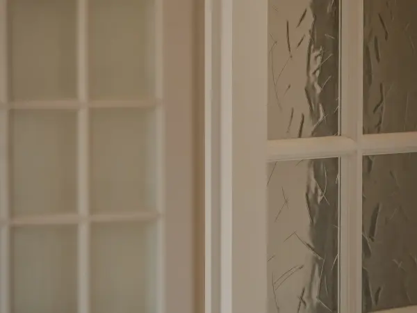Détail d'une porte vitrée à petits carreaux.